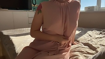 A Woman In A Soft Pink Dress Explores Her Own Sensuality